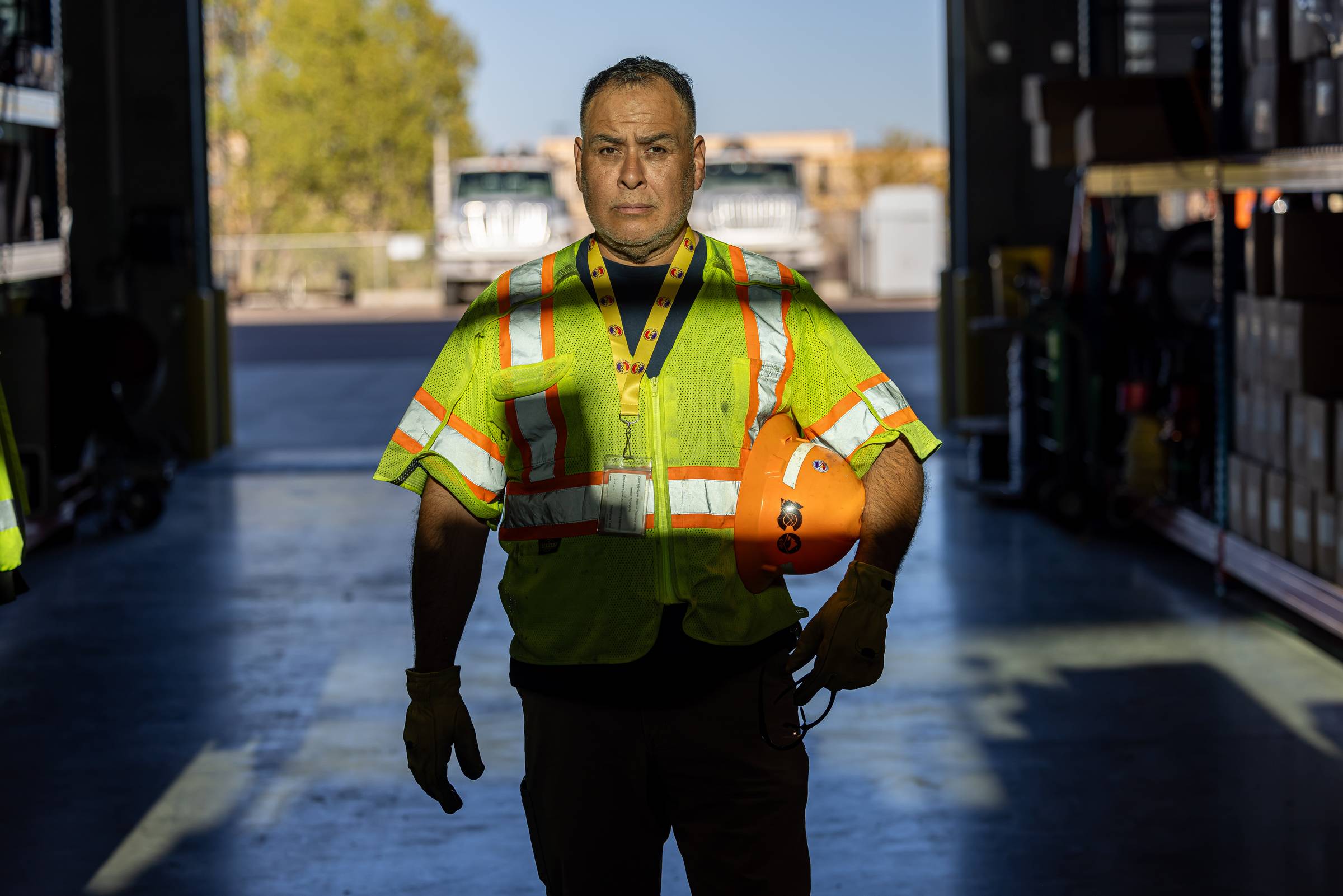 Man with serious expression holding hard hat wearing Colorado Department of Transportation uniform.